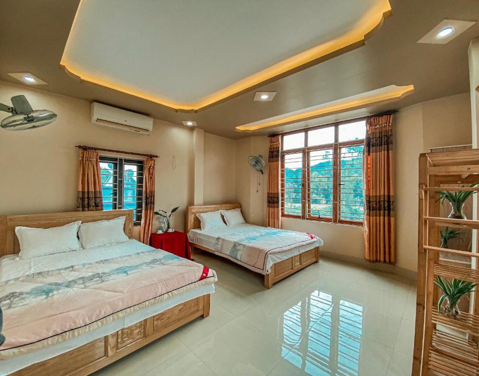 a bedroom with two beds and a window at Sơn Tùng Hostel in Cat Ba