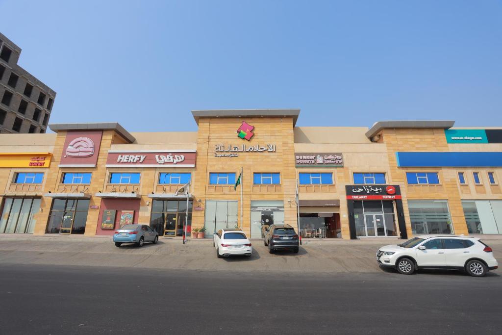 a building with cars parked in a parking lot at Quiet Dreams - Al Noor Branch in Jeddah