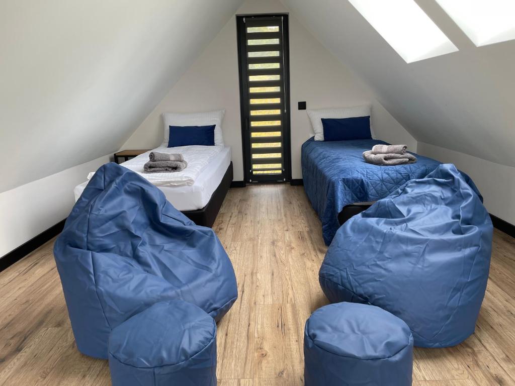 a attic bedroom with two beds and a couch at Zakątek na Lipowej in Komarno