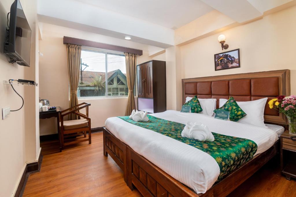 a bedroom with a large bed and a desk at Muscatel Roma - 400 Mts from Mall Road in Darjeeling