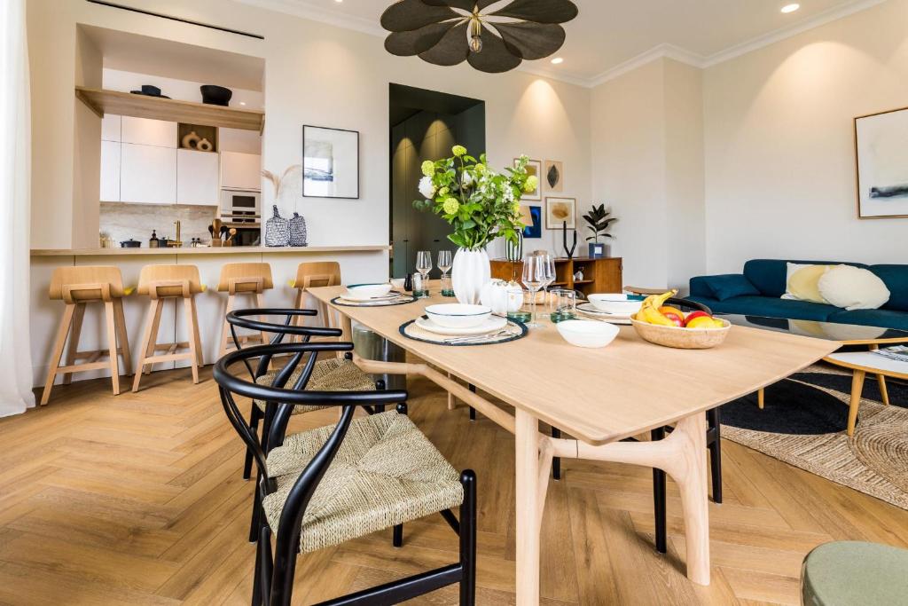 een eetkamer en een woonkamer met een tafel en stoelen bij HYGGE KEYWEEK Apt 2 bedrooms with parking in Biarritz city center in Biarritz