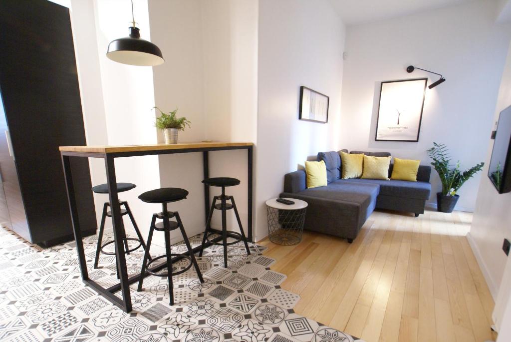 uma sala de estar com um sofá, uma mesa e bancos em Fingerprint Tree Apartments - Original em Zagreb