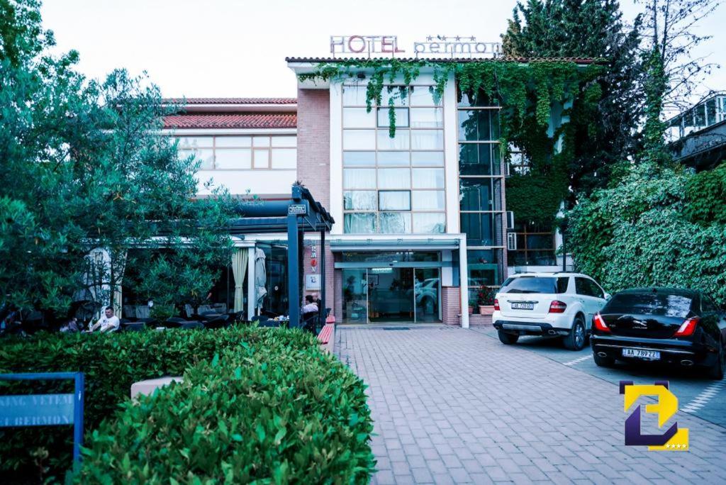 a building with cars parked in front of it at Hotel Bermon in Tirana