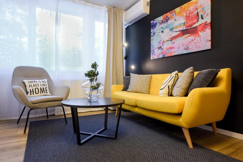 a living room with a yellow couch and a table at Lemonade - Stylish 1BR Apartment in Obor District in Bucharest