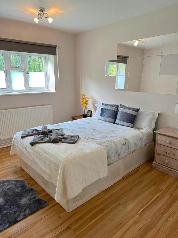 a bedroom with a large bed with blue pillows at 303 Alexandra Avenue HA2 9DX in Pinner