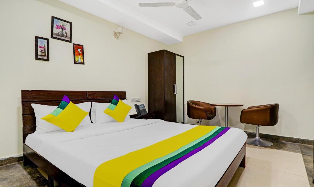 a bedroom with a large bed with a colorful blanket at Itsy By Treebo - Infinity Hitech City in Hyderabad