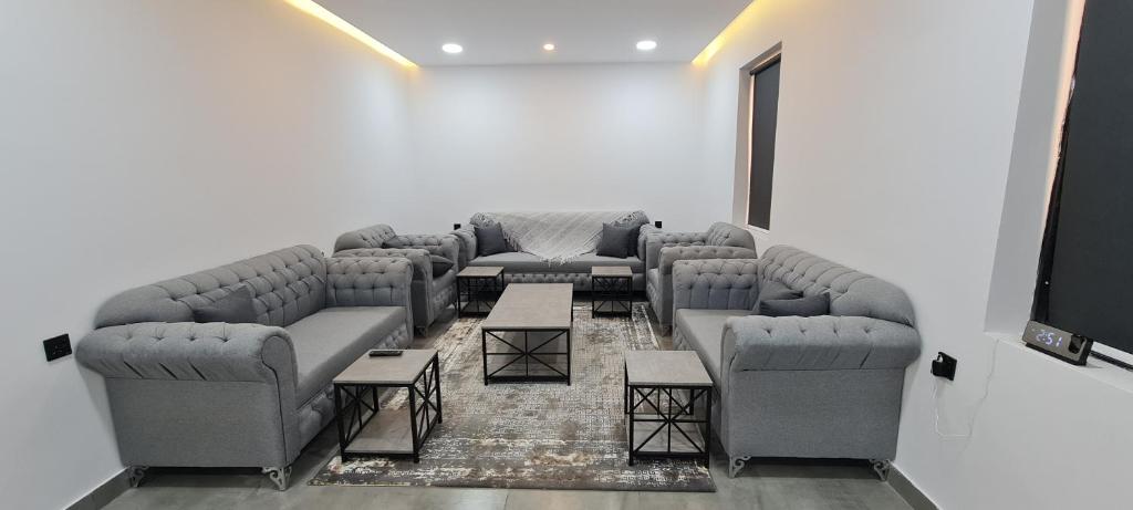 a living room with couches and a flat screen tv at Black in Al-ʿUla