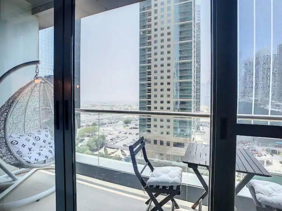 a room with a chair and an umbrella and a window at Luxury Modern Studio in JLT with Amazing View & Rooftop Pool - sleeps 3 in Dubai