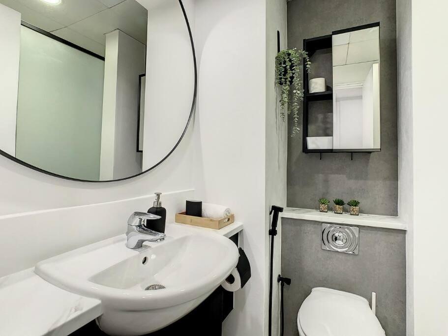 a bathroom with a sink and a mirror and a toilet at Luxury Modern Studio in JLT with Amazing View & Rooftop Pool - sleeps 3 in Dubai