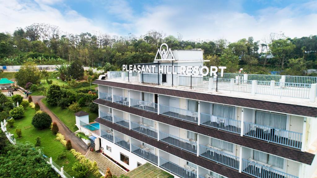 une vue aérienne d'un bâtiment avec un panneau sur celui-ci dans l'établissement Pleasant Hill Resort, à Munnar