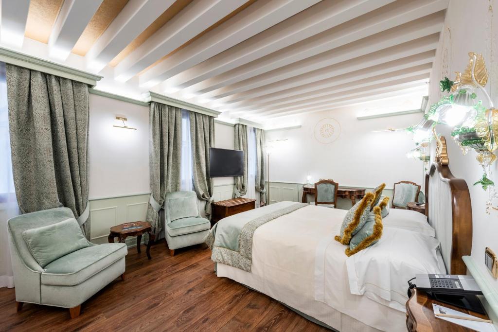 a hotel room with a bed and a chair at Monaco &amp; Grand Canal in Venice