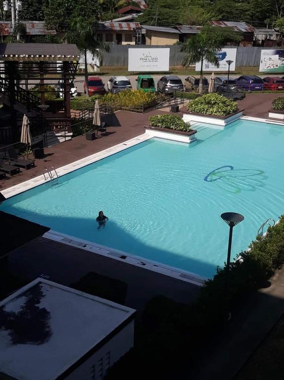 a person swimming in a large blue swimming pool at Dream haven 2 in Cagayan de Oro