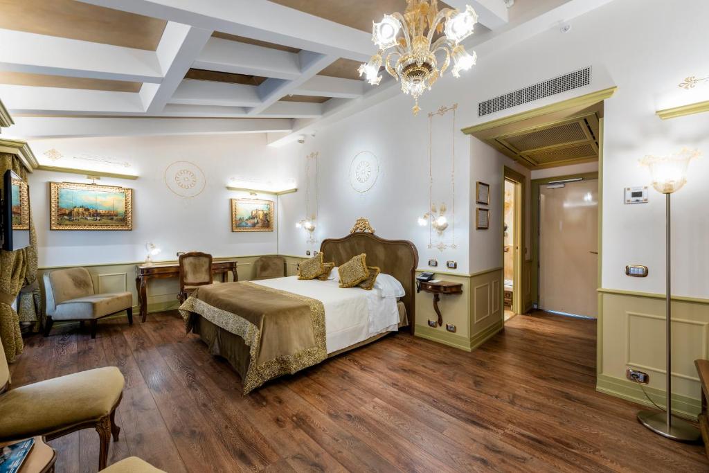 a bedroom with a bed and a table and chairs at Monaco &amp; Grand Canal in Venice