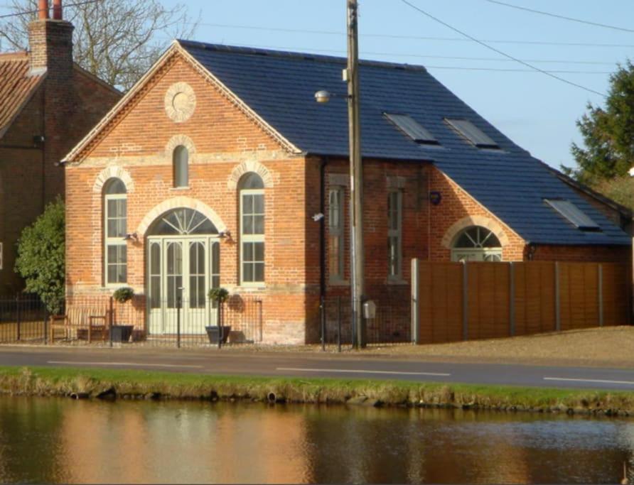 budynek z czerwonej cegły z czarnym dachem w obiekcie The Old Methodist Chapel w mieście Great Massingham