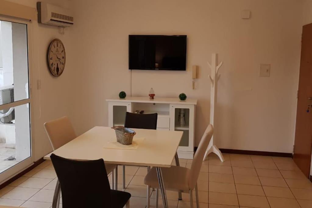 a dining room with a table and a tv on the wall at Departamento luminoso amplio y silencioso. in Rosario