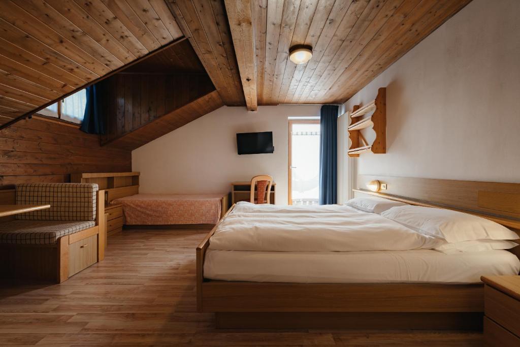 Postel nebo postele na pokoji v ubytování Hotel La Montanara Predazzo
