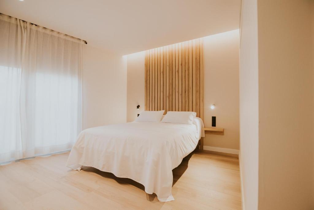 a bedroom with a white bed and a large window at Casa La Picuda in San Vicente de la Sonsierra