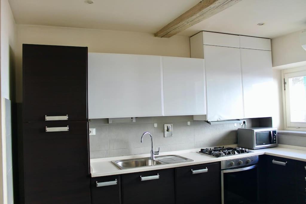 kuchnia z białymi szafkami i zlewem w obiekcie Modern 3BR Near Santa Maria Novella Station we Florencji
