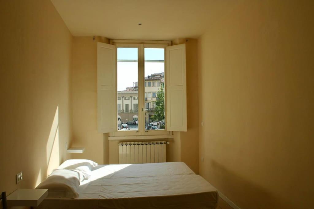 sypialnia z łóżkiem przed oknem w obiekcie Modern 3BR Near Santa Maria Novella Station we Florencji