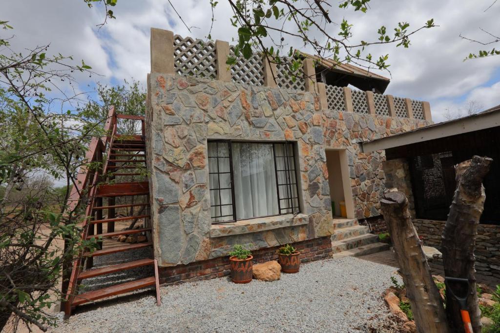 a stone house with a staircase next to a building at Oasis in the Wild @Marloth in Marloth Park