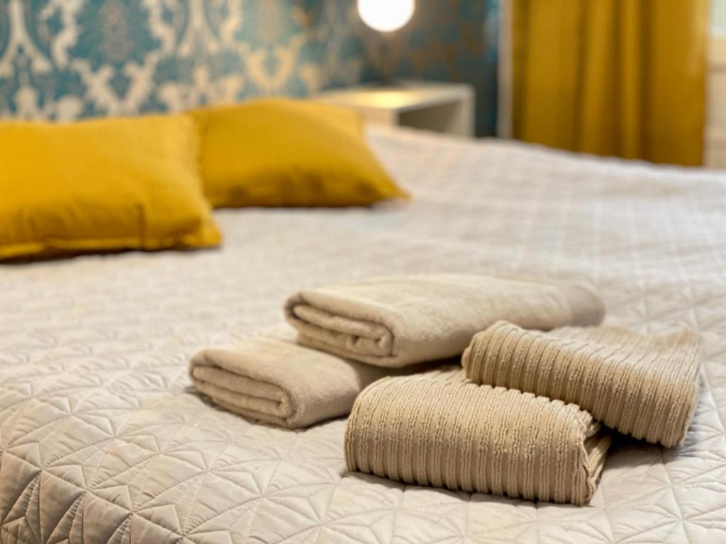 Una cama con tres toallas encima. en Porvoon Kartanonpuisto, en Porvoo