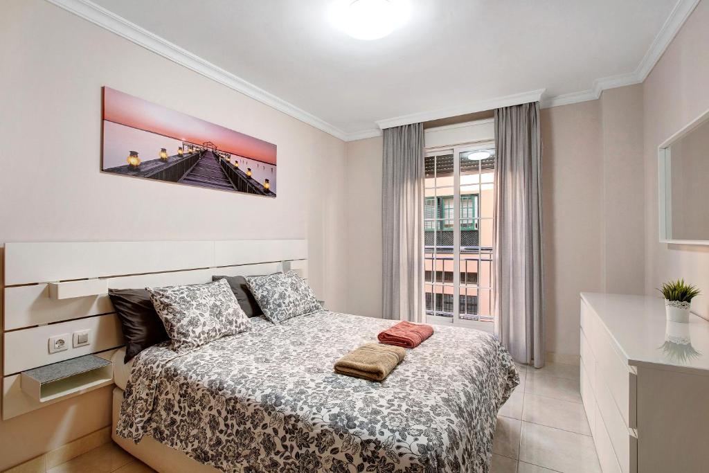 a white bedroom with a bed and a window at Apartamento Isla Bonita in Guía de Isora