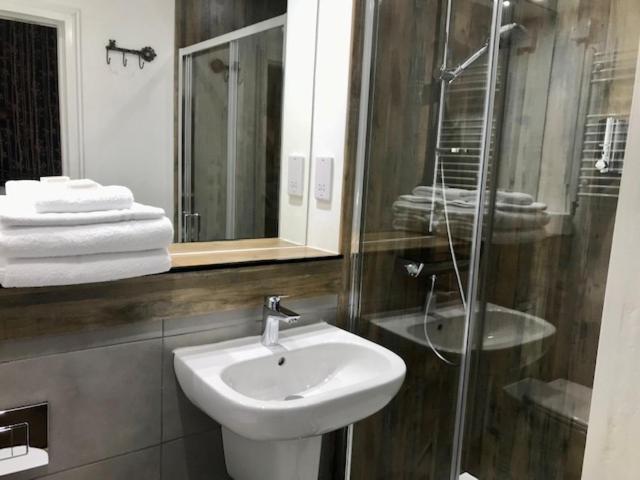 a bathroom with a sink and a glass shower at Lunan House in Arbroath