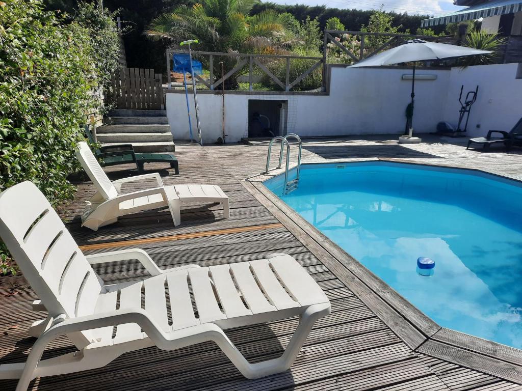 een terras met 2 stoelen en een zwembad bij MAISON/PISCINE 5mn de Bayonne 12 de Biarritz in Mouguerre