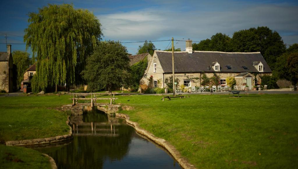 a house and a river in front of a building at Kings Head Inn in Bledington