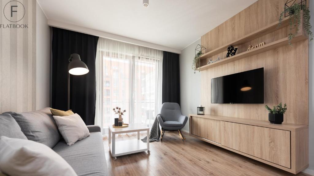 Televízia a/alebo spoločenská miestnosť v ubytovaní Flatbook - City Center SPA Apartments Motlawa