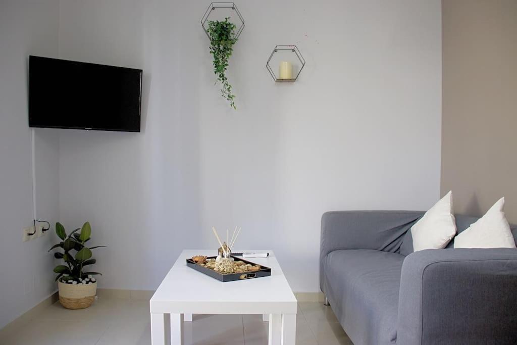 ein Wohnzimmer mit einem Sofa und einem Tisch in der Unterkunft Cozy Apartment In The Heart Of The City in Iraklio