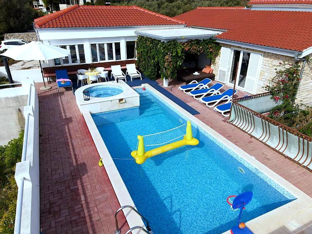 a pool with a slide in the middle of a house at Villa Lucia with private pool and a whirlpool in Vis