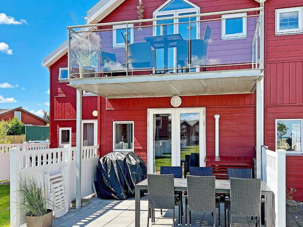 une maison rouge avec une table et des chaises devant elle dans l'établissement 6 person holiday home in Hadsund, à Hadsund