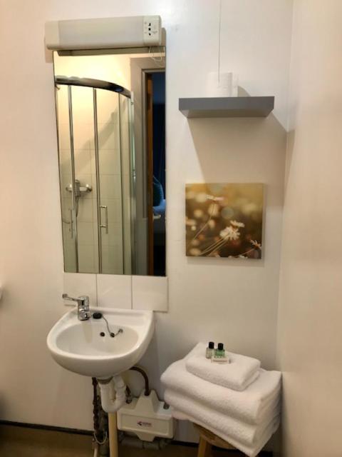 a white bathroom with a sink and a mirror at Lunan House in Arbroath