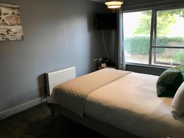 a bedroom with a large bed and a window at Lunan House in Arbroath