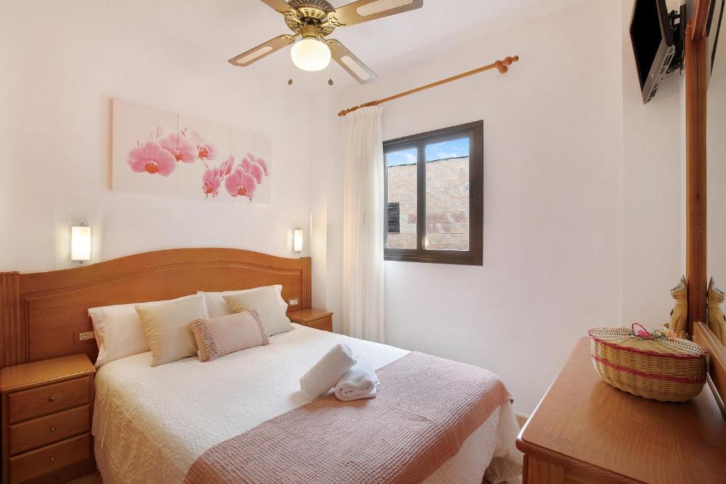 um quarto com uma cama e uma ventoinha de tecto em Casa Nanda em Fasnia