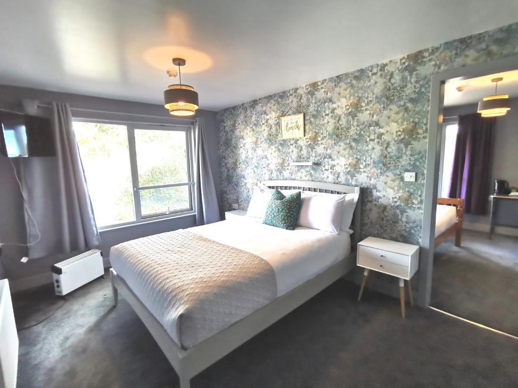 a bedroom with a large bed with floral wallpaper at Lunan House in Arbroath