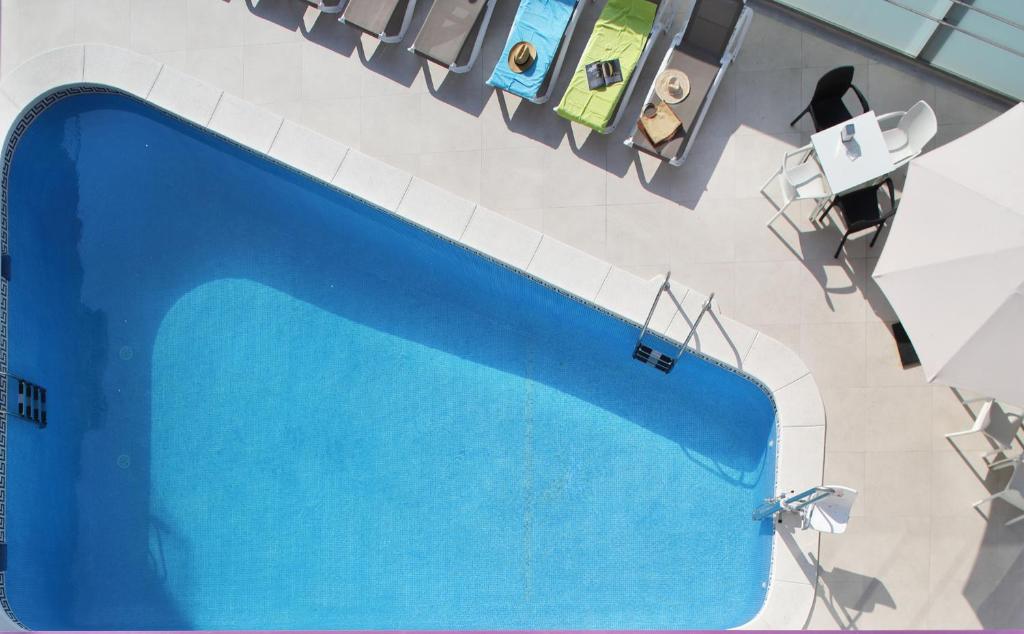 an overhead view of a large blue swimming pool at Hotel Brasil in Benidorm