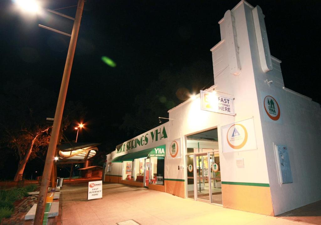 un edificio blanco con una luz de la calle delante de él en YHA Alice Springs, en Alice Springs