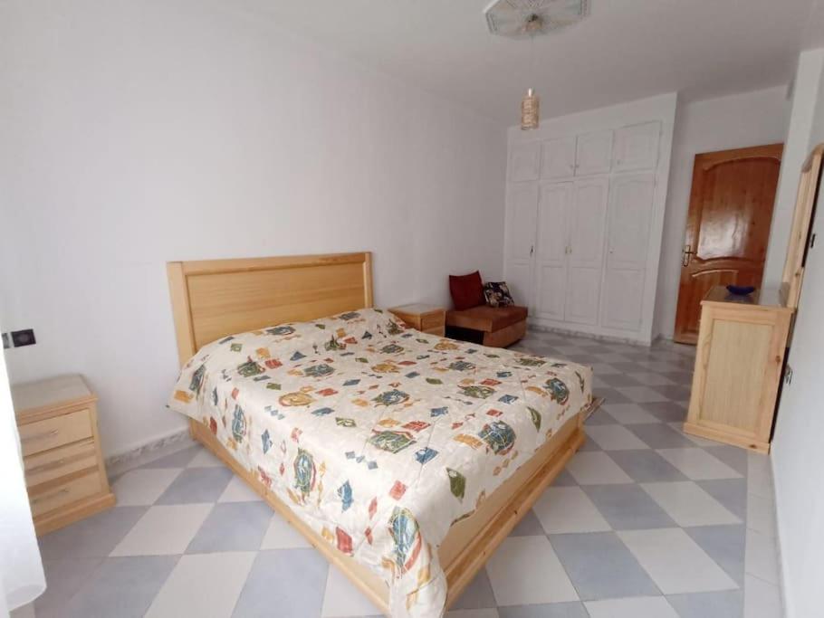 een slaapkamer met een bed en een tegelvloer bij appartement 2chambres et un salon in Chefchaouene