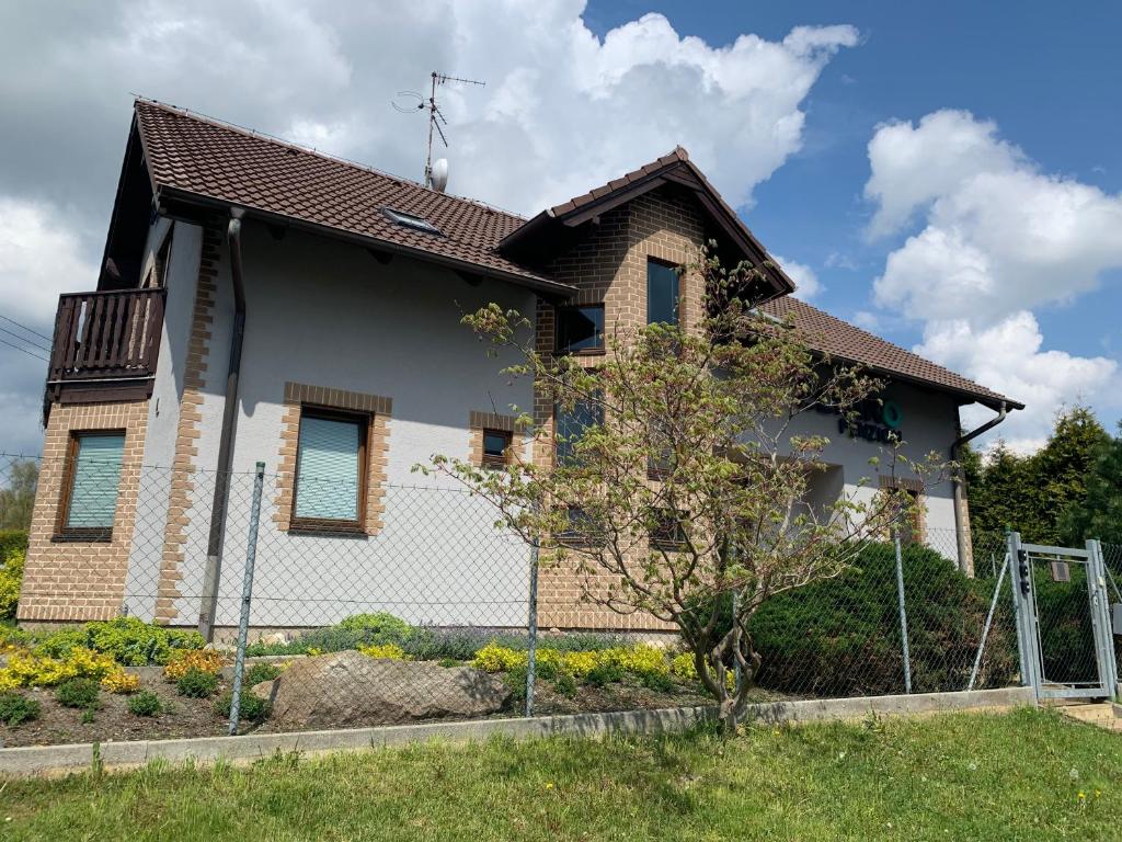 uma casa com uma cerca em frente em ELTAKO penzion em Karlovy Vary