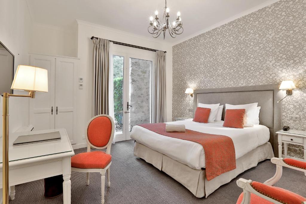 ein Hotelzimmer mit einem Bett, einem Schreibtisch und einem Bett in der Unterkunft Château des Vigiers in Monestier