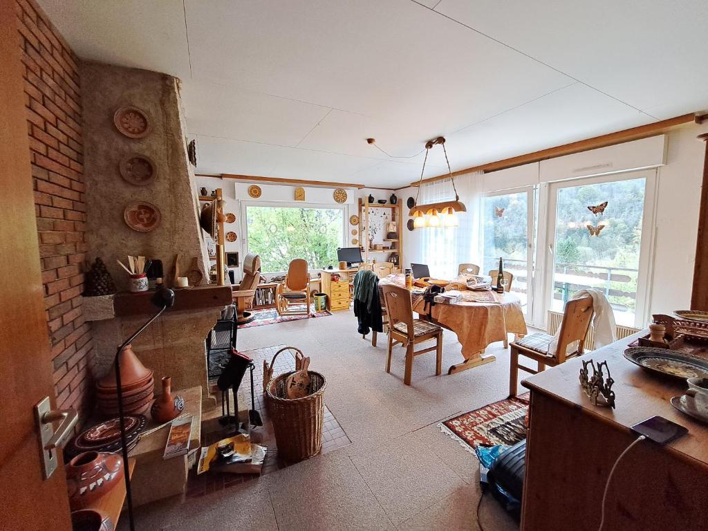 a living room with a table and a dining room at Cosy house in picturesque Jura in Doucier