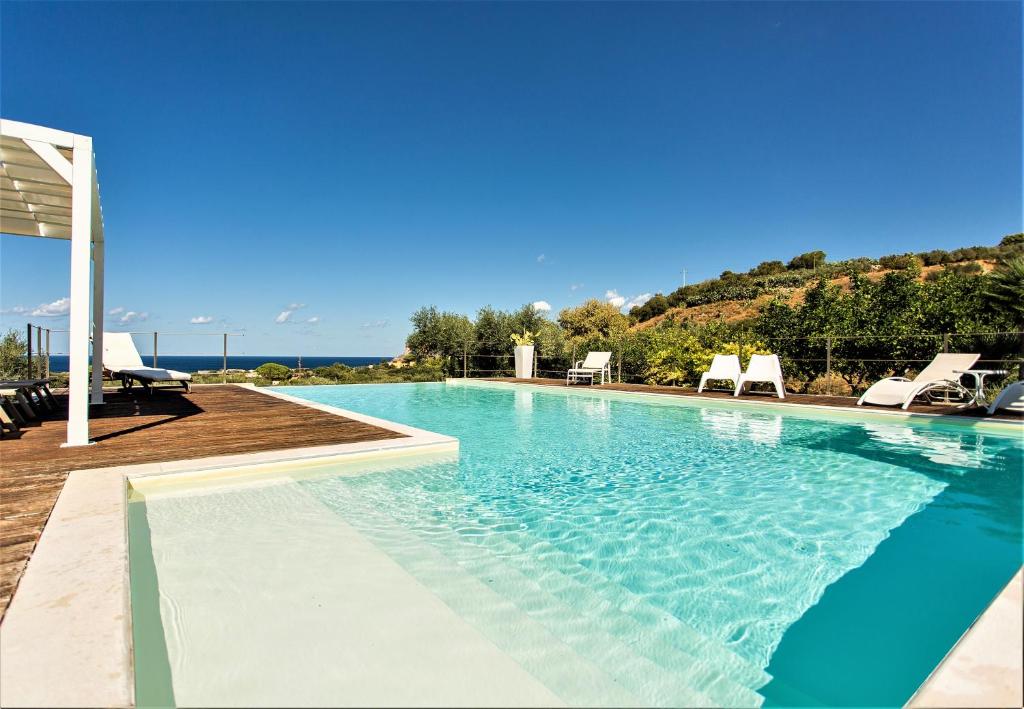 einen Pool mit Liegestühlen in einem Resort in der Unterkunft Villa Maria una finestra sul mare in Valderice