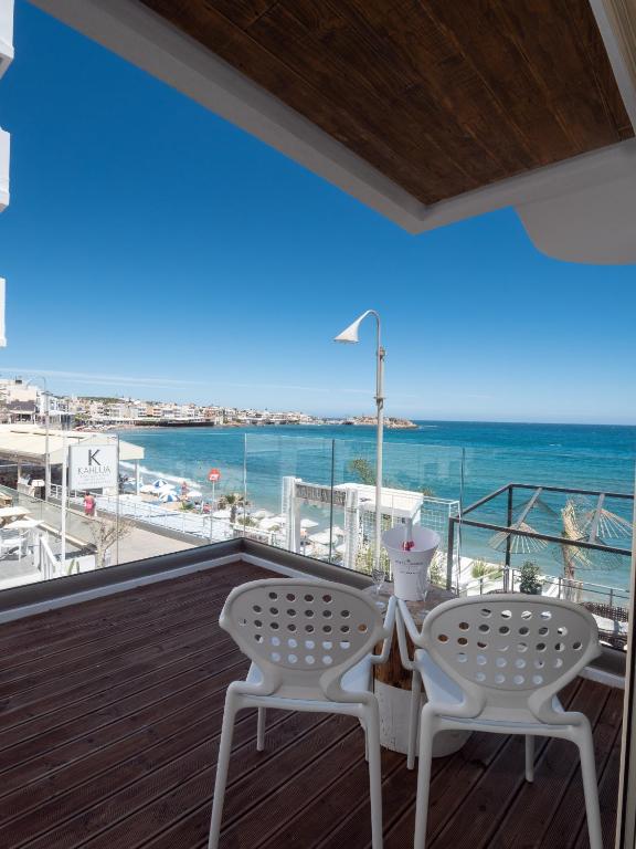a balcony with two chairs and a view of the ocean at Kahlua Sea View Suites - Adults Only in Hersonissos