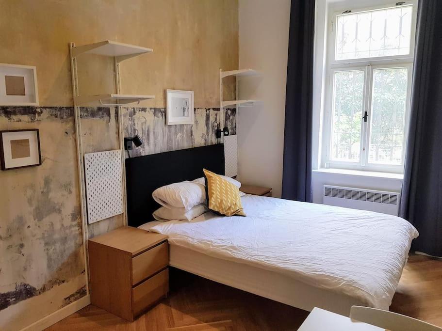 - une petite chambre avec un grand lit et une fenêtre dans l'établissement Stylish studio apartment by Namesti Miru, à Prague