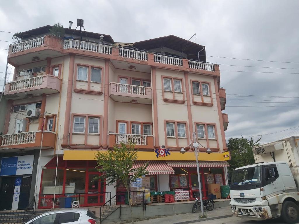 a building on a street with a truck in front of it at Ayça Konaklama in Sakarya