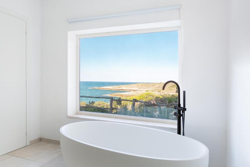 a white bath tub in a bathroom with a window at Sfinal Residence in Peschici