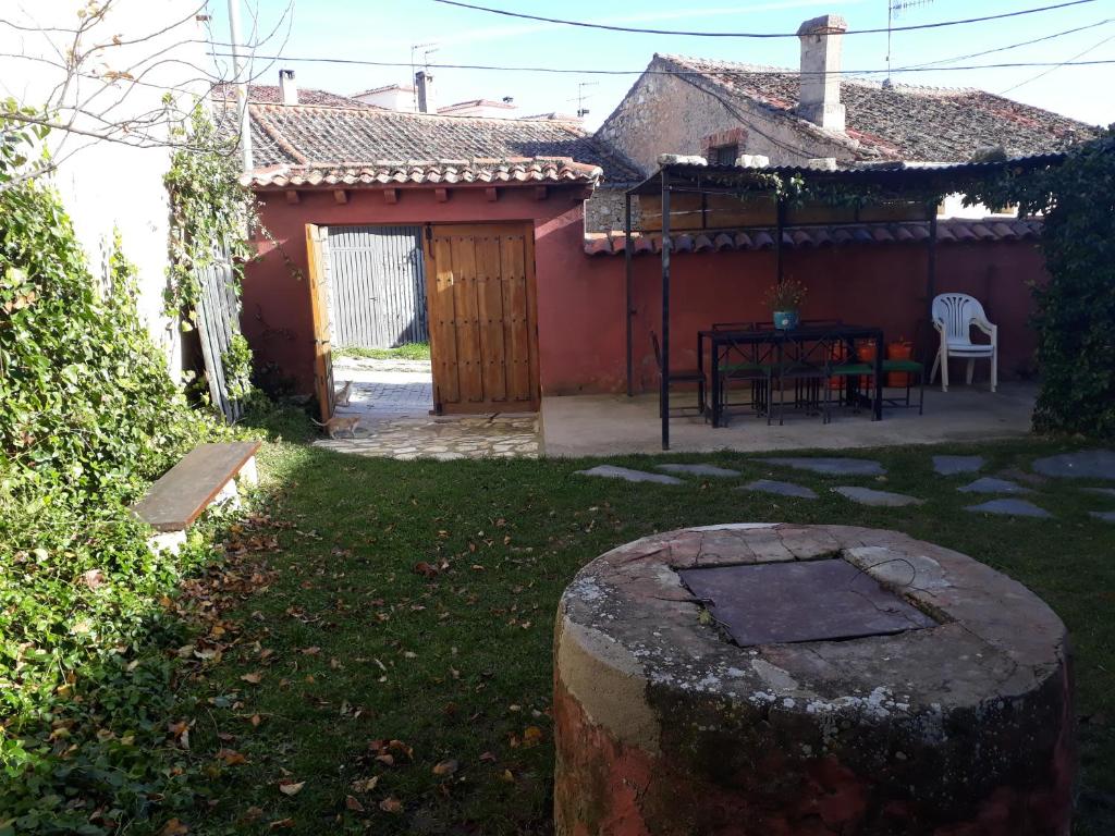 una pequeña casa con una mesa y sillas en un patio en Casa El Secretario, en El Arenal
