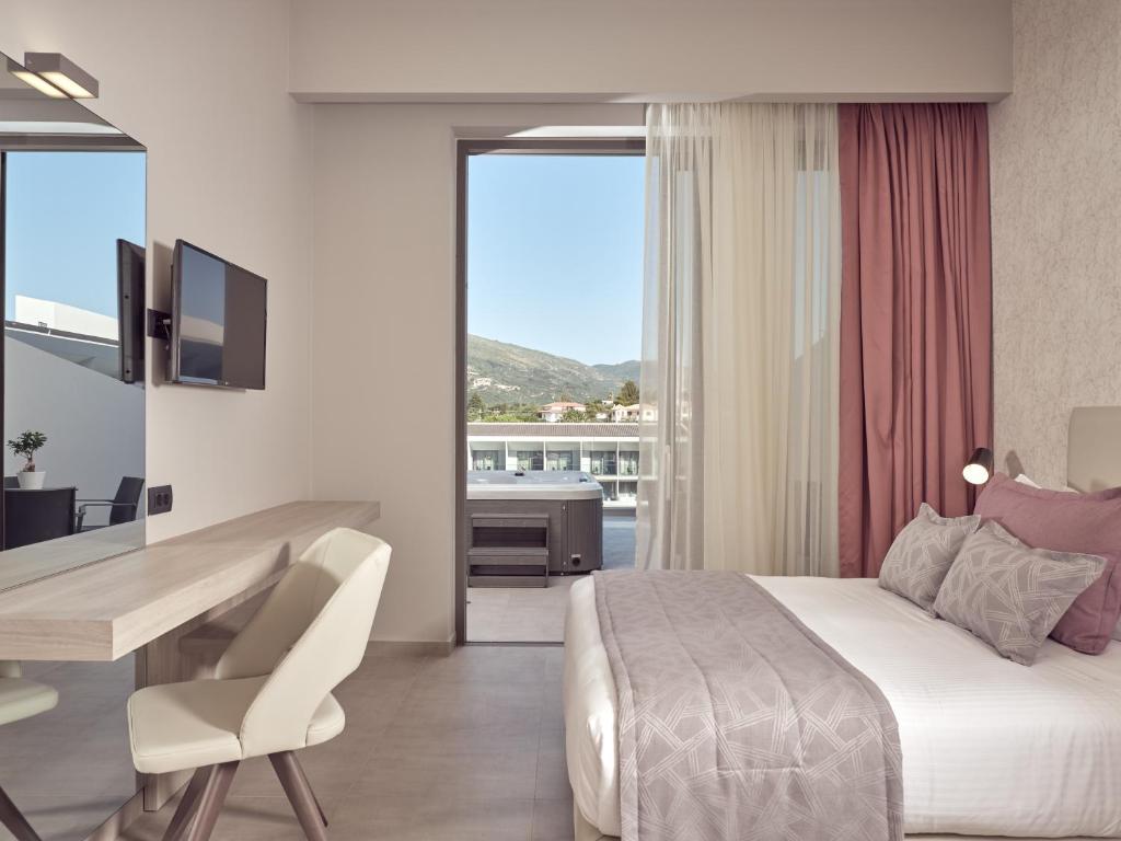 a bedroom with a bed and a desk and a table and chair at Zante Sun Resort in Lithakia